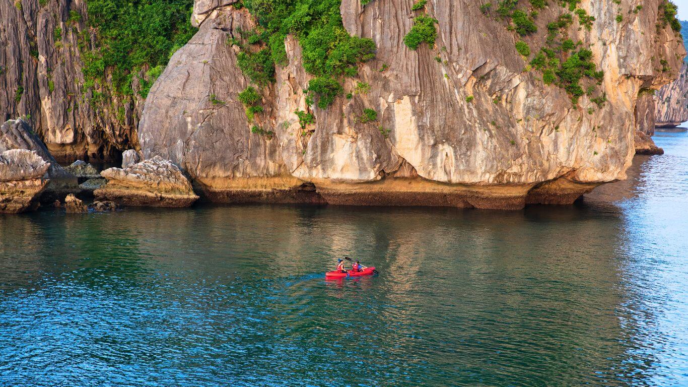 Kayaking between Ba Trai Dao's three limestone islets in crystal-clear water, Lan Ha Bay Vietnam — the best way to experience the Three Peaches up close