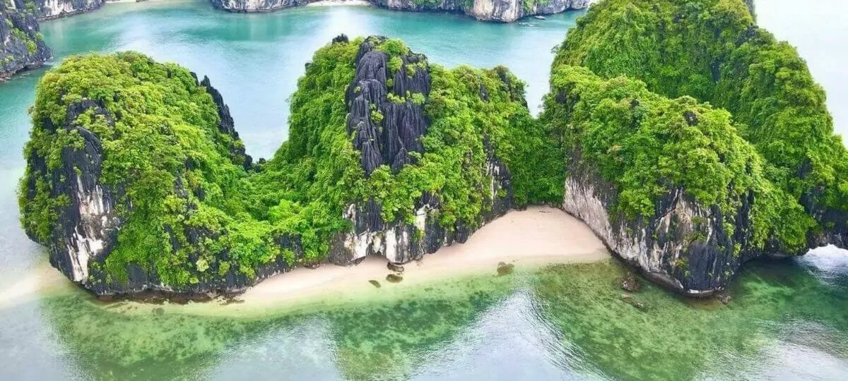 Ba Trai Dao Islets (Three Peaches) — three rounded limestone islets enclosing a crescent white sand beach in Lan Ha Bay, Vietnam