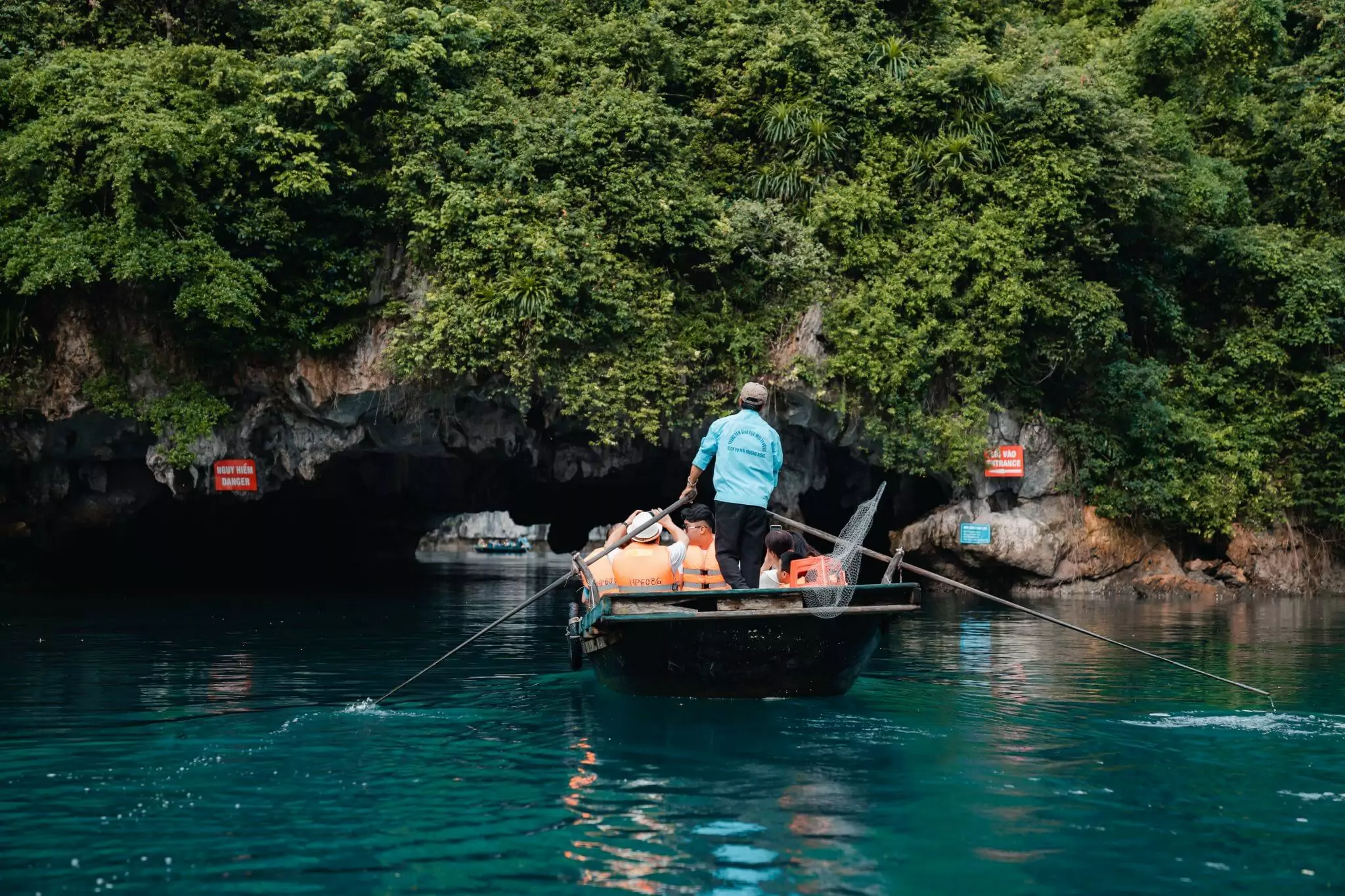 Hidden lagoon inside Dark and Bright Cave — a 1km-wide enclosed emerald lagoon surrounded by towering limestone cliffs, Lan Ha Bay Vietnam