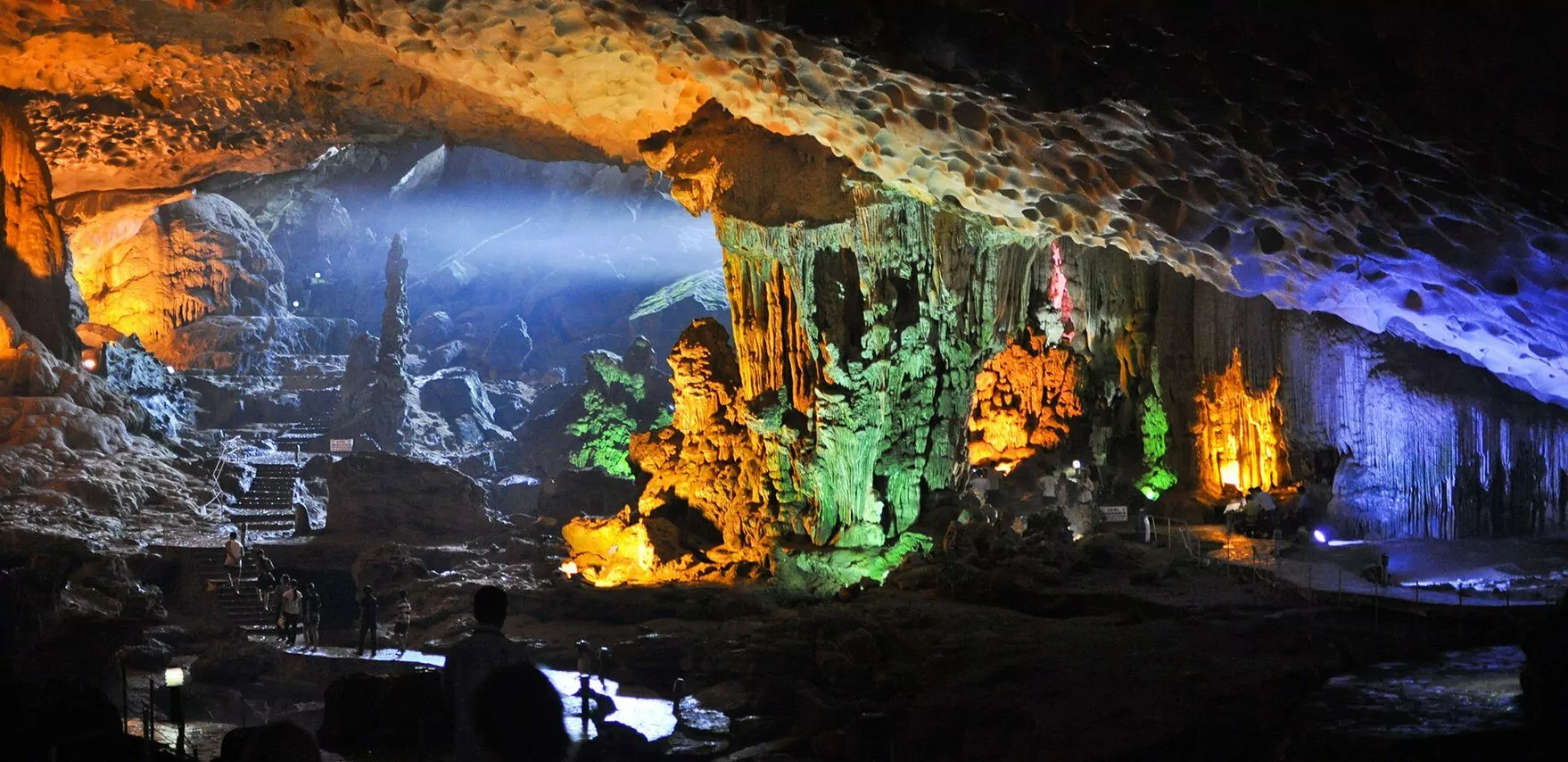 Stone stairway leading to Dau Go Cave's wide jellyfish-shaped entrance on Dau Go Island, Halong Bay Vietnam