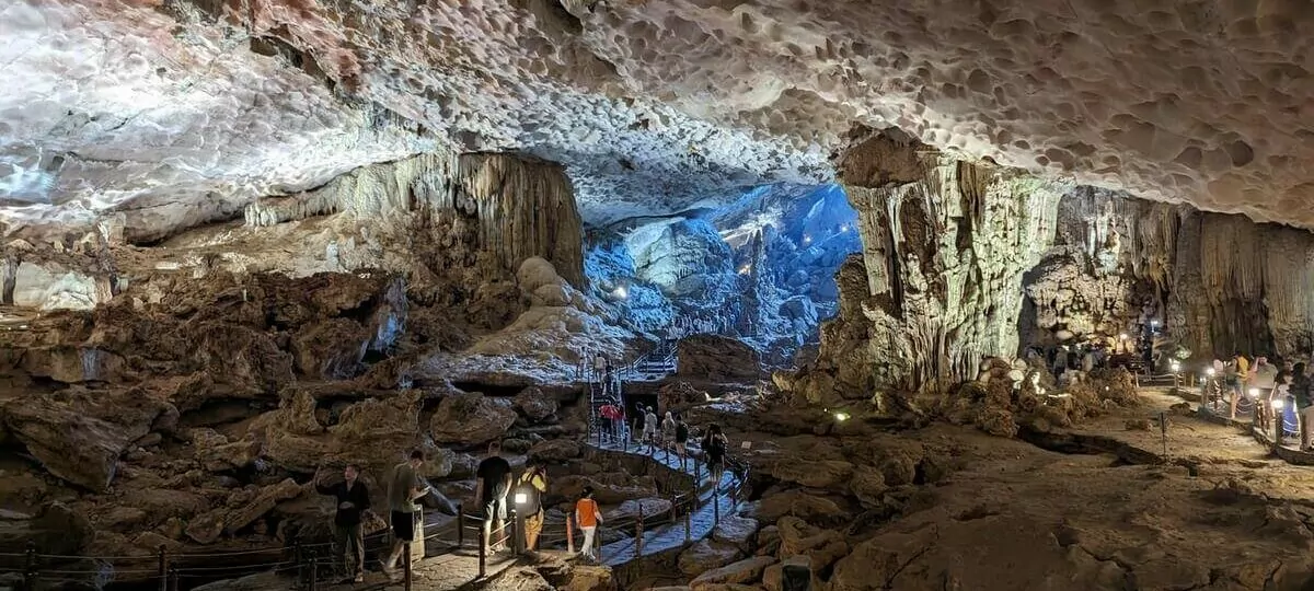 Dau Go Cave interior — towering stalactite columns lit by natural sunlight, Cave of Wooden Stakes, Halong Bay Vietnam