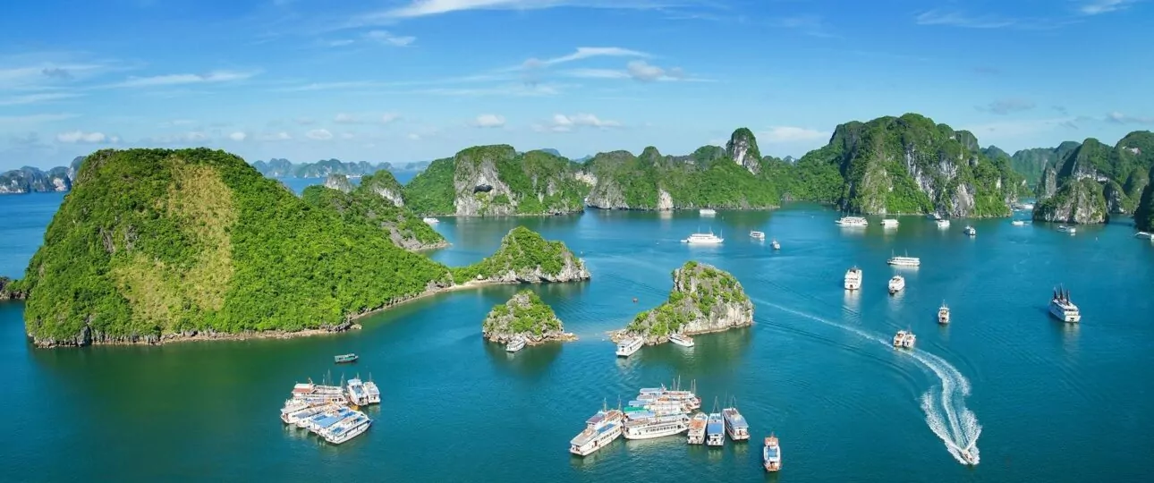 Aerial view of Halong Bay attractions — limestone karst islands rising from emerald waters, UNESCO World Heritage Site, Vietnam