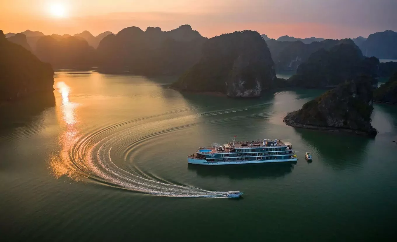 Lan Ha Bay cruise sailing at sunset among limestone karst islands — overnight cruise on Vietnam's UNESCO World Heritage bay, 2026