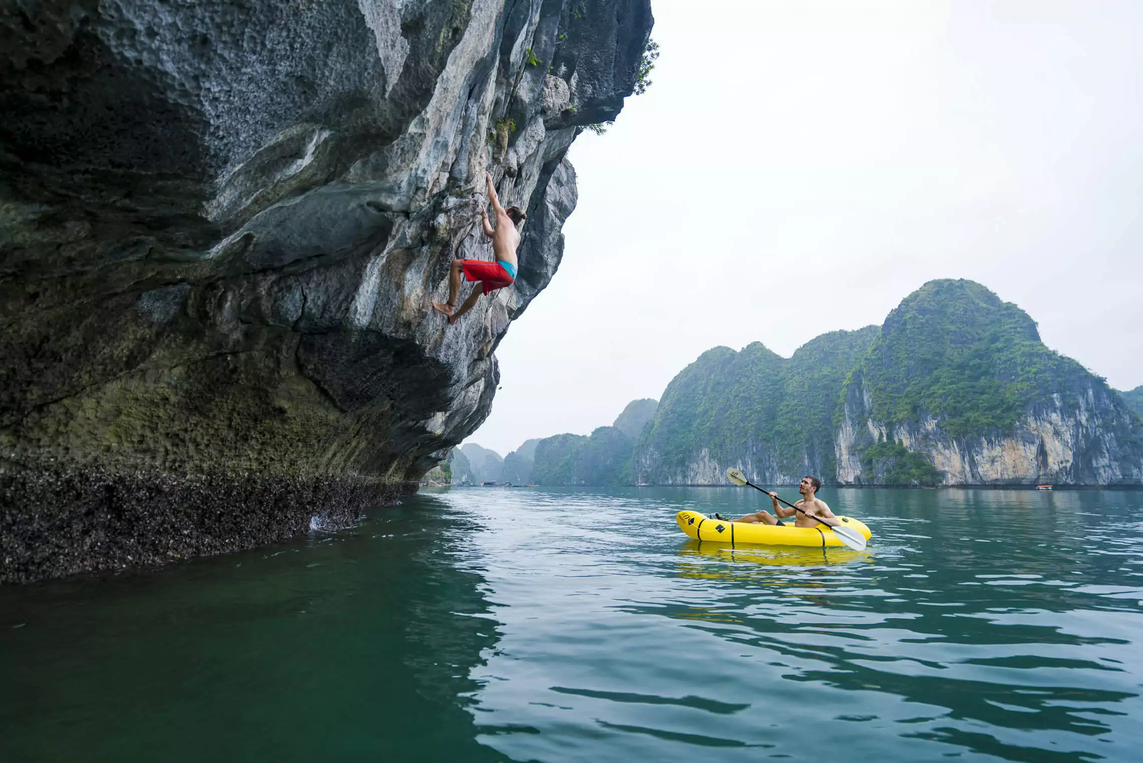 Deep water soloing rock climbing on Van Boi Island limestone cliffs, one of Southeast Asia's top climbing destinations, Lan Ha Bay Vietnam