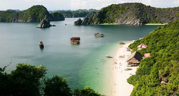 Soi Sim Island's pristine white sand beach with crystal-clear emerald water — one of Halong Bay's quietest and most beautiful swimming beaches