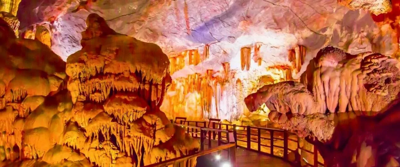 Thien Cung Cave interior — colorful lighting on dramatic stalactite formations, Heavenly Palace Cave, Halong Bay Vietnam