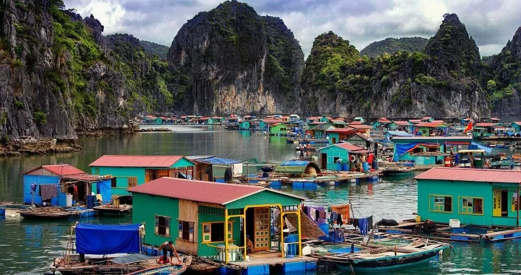 Vung Vieng Fishing Village colorful floating houses on the emerald waters of Bai Tu Long Bay, surrounded by limestone cliffs, Vietnam