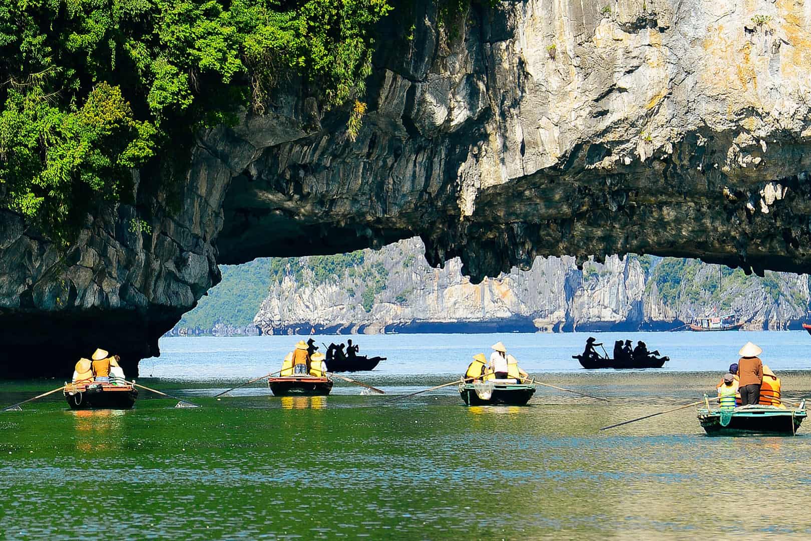 Luon Cave's enclosed lagoon with mirror-calm water reflecting surrounding limestone cliffs, Halong Bay's secret hidden paradise, Vietnam