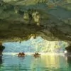 Kayaking through Luon Cave's 60-meter limestone tunnel into the hidden lagoon, Halong Bay's iconic kayaking experience, Vietnam
