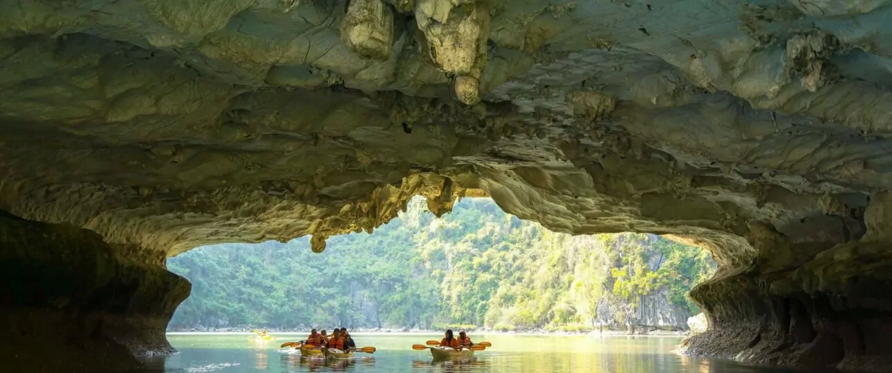 Kayaking through Luon Cave's 60-meter limestone tunnel into the hidden lagoon, Halong Bay's iconic kayaking experience, Vietnam