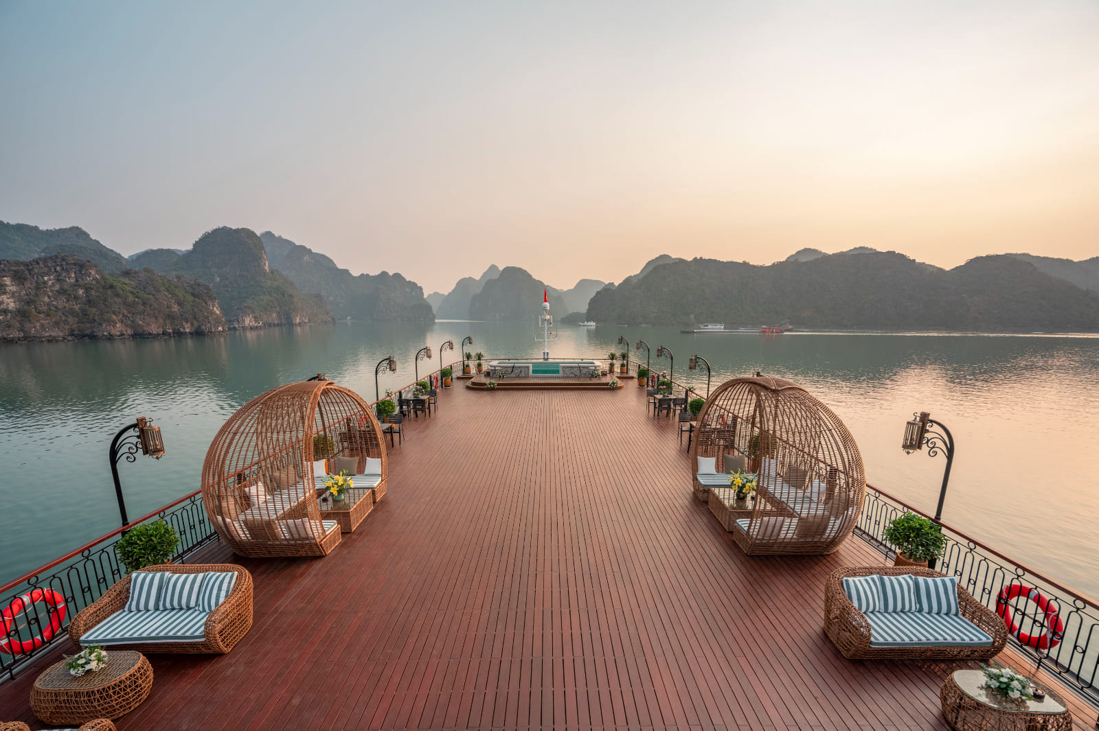 Sundeck with rattan pod lounges on Indochine Grand Cruise overlooking Halong Bay