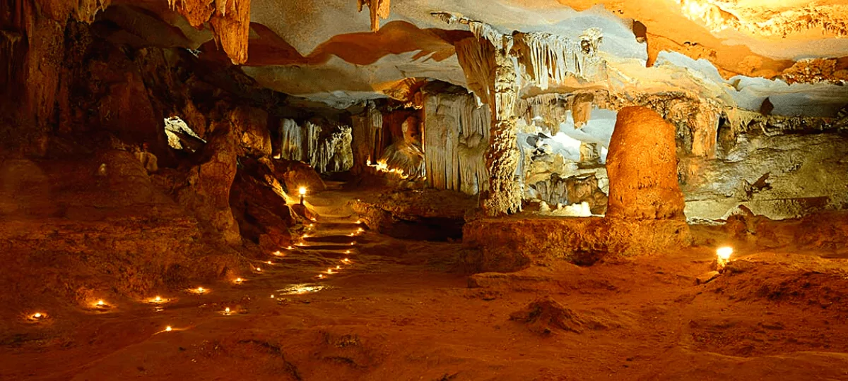 Thien Canh Son Cave interior — stalactite formations resembling lotus flowers and chandeliers, Bai Tu Long Bay's most spectacular cave, Vietnam