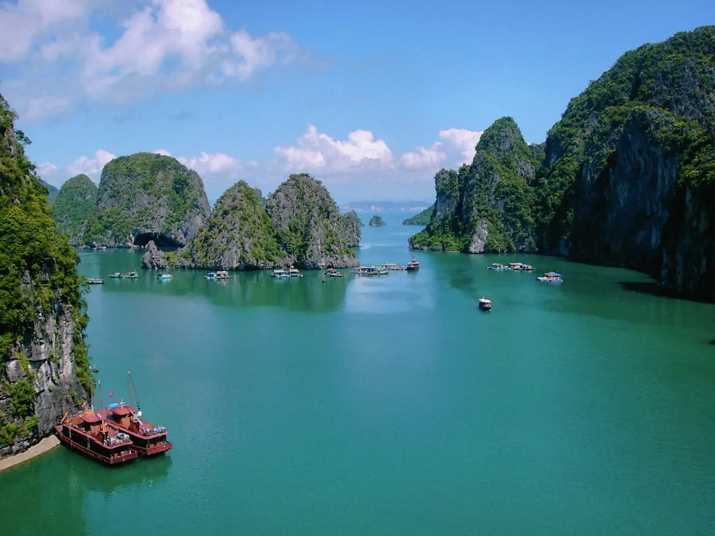 Panoramic view of Bai Tu Long Bay from Thien Canh Son Cave's entrance viewpoint — limestone islands and emerald water, Cong Do Nature Reserve, Vietnam
