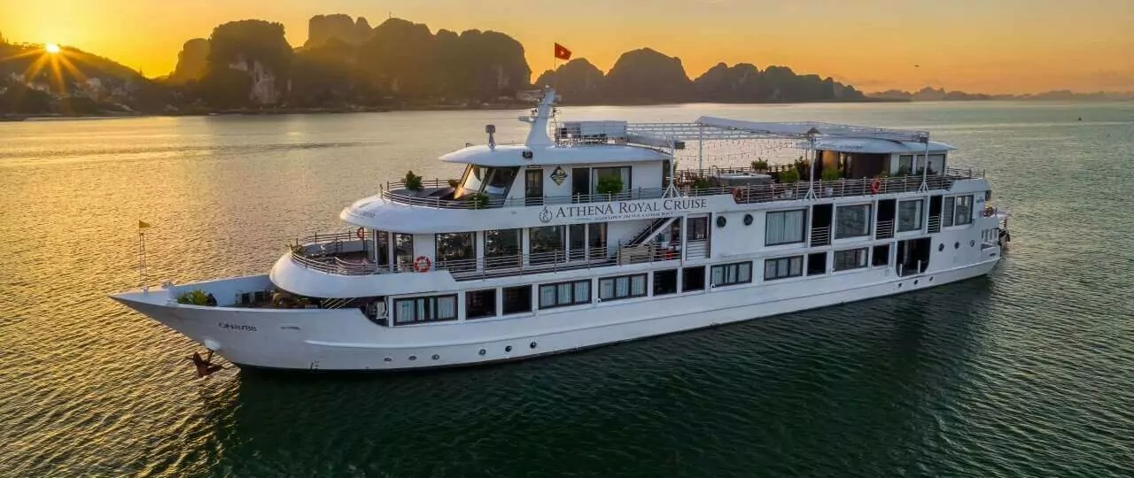 Athena Royal Cruise Halong Bay sailing at sunset in Bai Tu Long Bay