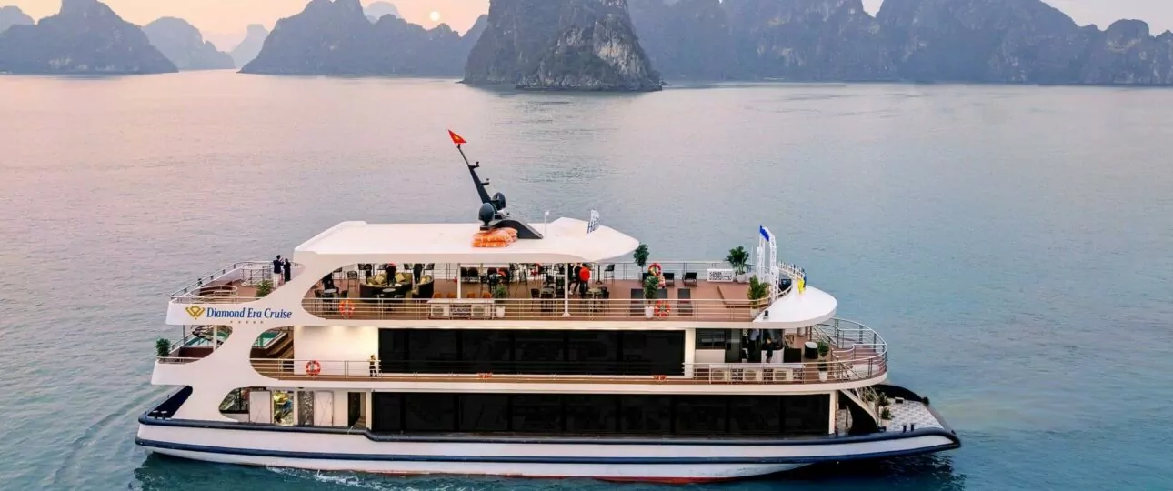 Diamond Era Cruise sailing Halong Bay at sunset with limestone karsts