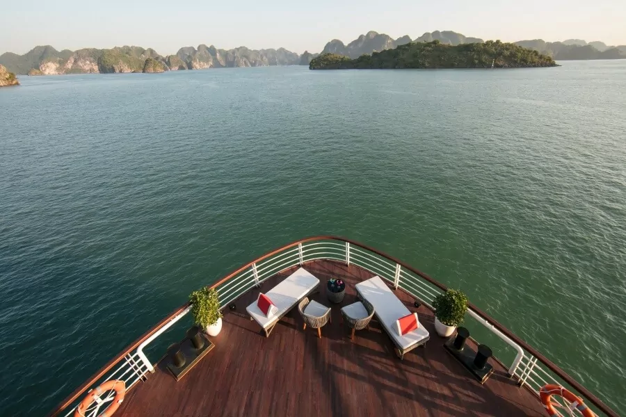 Relax on the bow deck lounge of Heritage Binh Chuan Cruise with panoramic Lan Ha Bay views.
