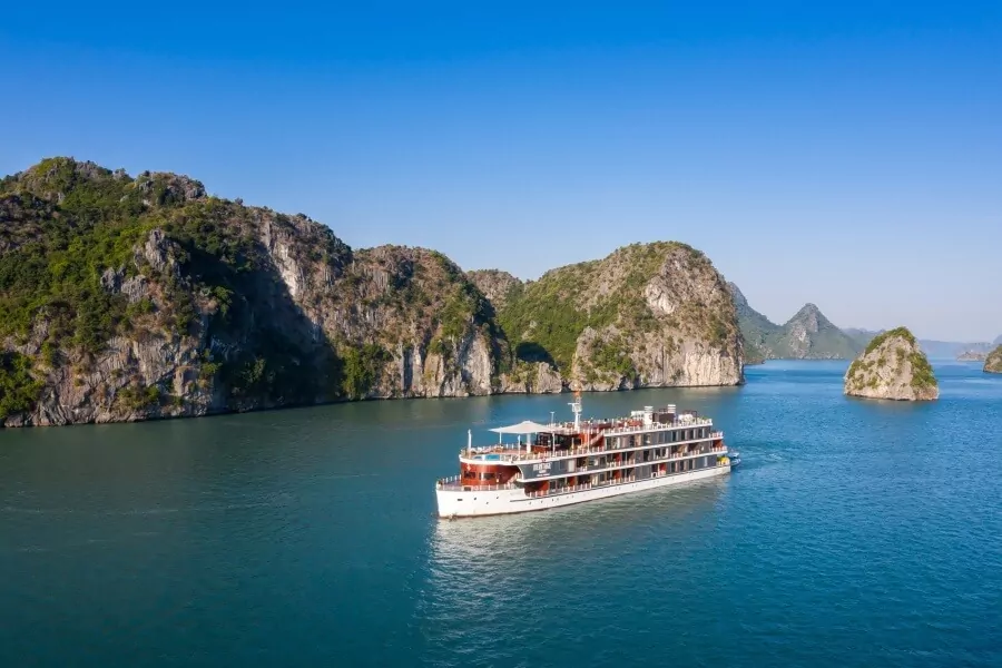 Heritage Binh Chuan Cruise cruising past towering limestone karsts in Lan Ha Bay.