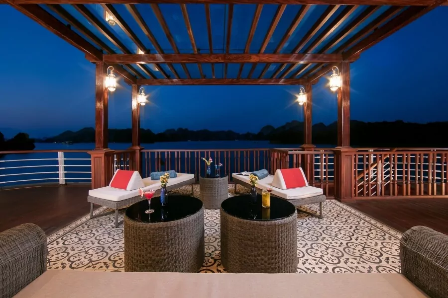 The Brezzy Outdoor Lounge on Heritage Binh Chuan Cruise, lit up for evening cocktails.