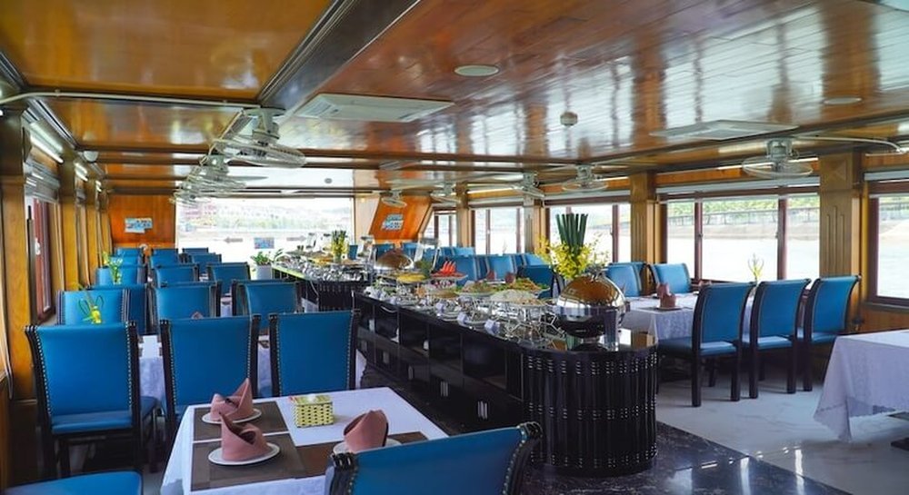 Dining area with blue chairs and bay-view windows