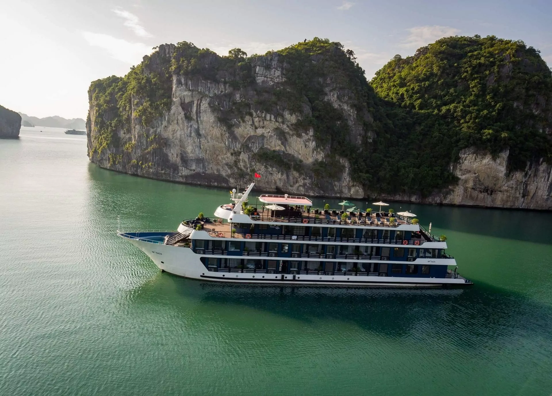 Side profile of Rosy Cruise, a 5-star deluxe cruise ship exploring Halong Bay.