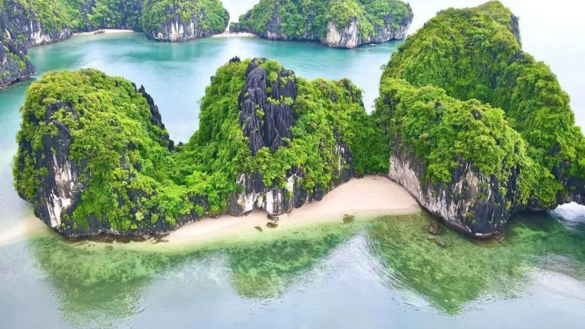 Ba Trai Dao Islets (Three Peaches) — three rounded limestone islets enclosing a crescent white sand beach in Lan Ha Bay, Vietnam