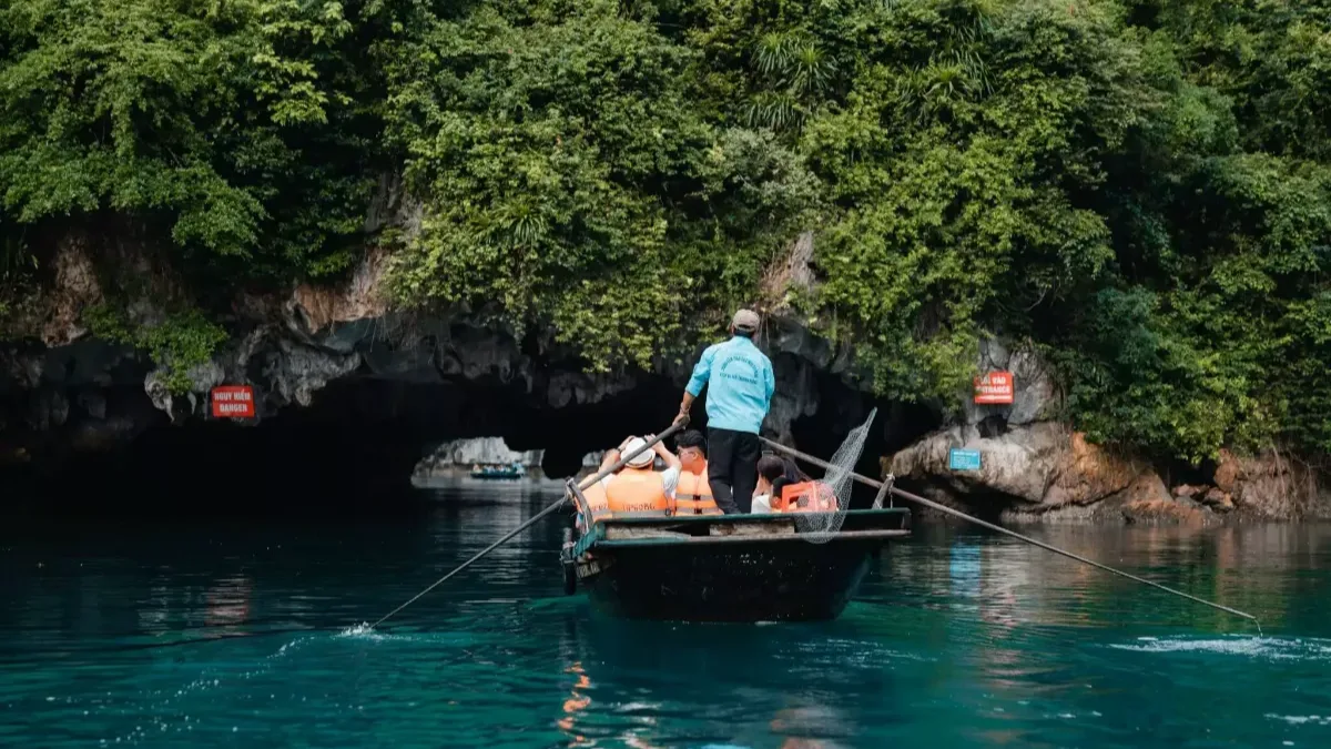 Hidden lagoon inside Dark and Bright Cave — a 1km-wide enclosed emerald lagoon surrounded by towering limestone cliffs, Lan Ha Bay Vietnam