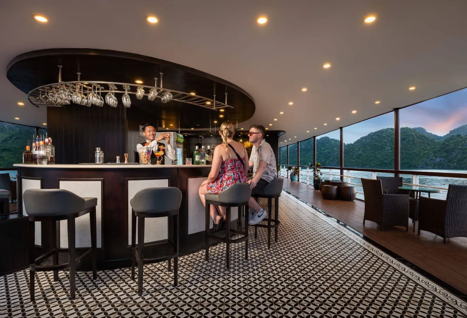 Guests enjoy sunset cocktails at the Sky Bar aboard Le Journey Elegance Cruise, Halong Bay