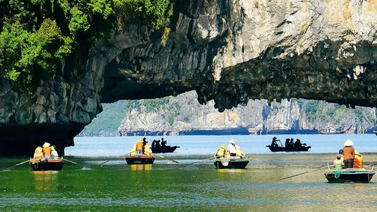 Luon Cave's enclosed lagoon with mirror-calm water reflecting surrounding limestone cliffs, Halong Bay's secret hidden paradise, Vietnam