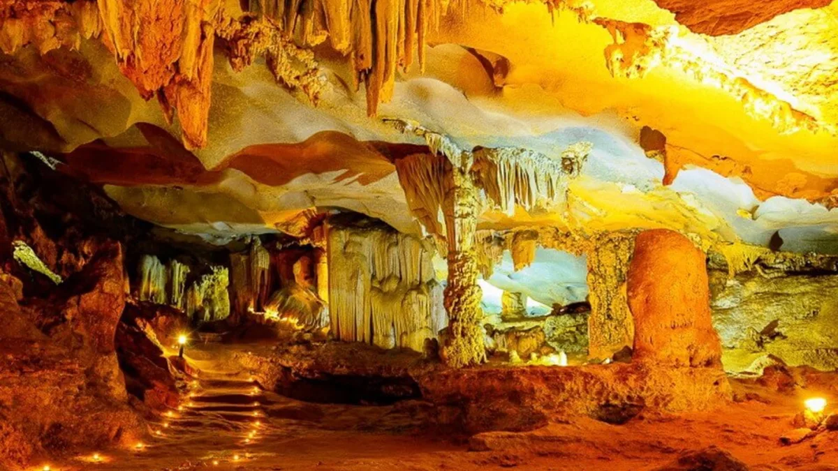 Inside Thien Canh Son Cave — limestone stalactite formations across three chambers, Bai Tu Long Bay's only major cave, Vietnam