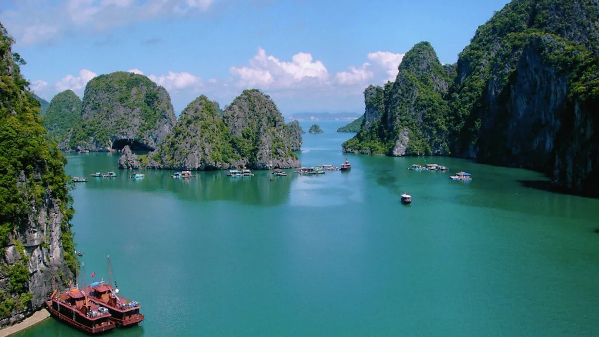Panoramic view of Bai Tu Long Bay from Thien Canh Son Cave's entrance viewpoint — limestone islands and emerald water, Cong Do Nature Reserve, Vietnam